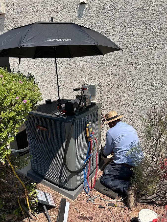 HVAC technician performing outdoor AC maintenance in Bellbrook