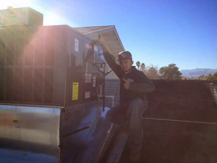 HVAC technician performing Boiler Repair on a rooftop unit in Bellbrook